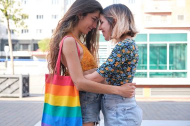 Lezbiyen çift sokakta sarılıp gülümsüyor..