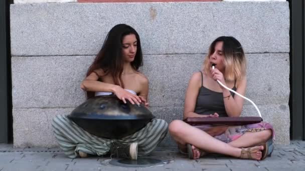 两个女人在街上靠在墙上弹奏着手风琴和吹奏着口琴 — 图库视频影像