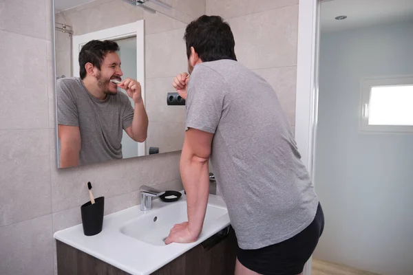Pria Latin Muda Menggosok Giginya Depan Cermin Kamar Mandi Pagi — Stok Foto