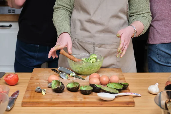 Unrecognizable woman smashing avocados. Cooking mediterranean and healthy food.