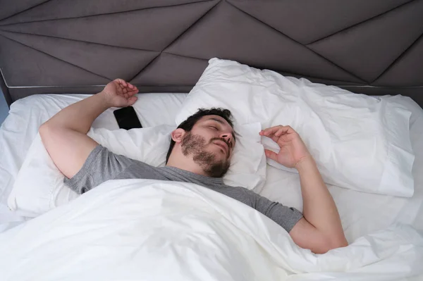 Pria Latin Muda Tidur Menyebar Tempat Tidur Dengan Smartphone Nya — Stok Foto