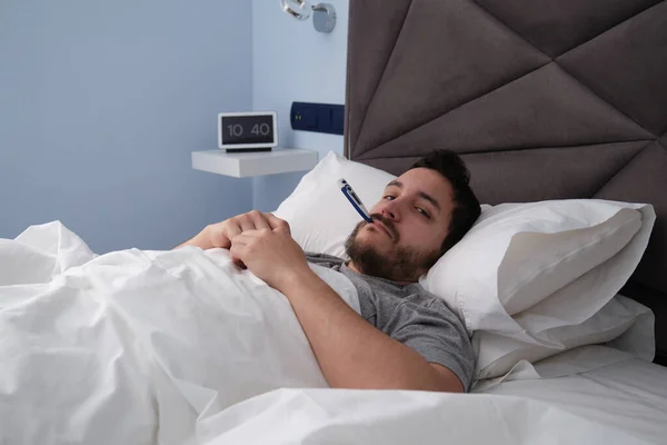 Pria Latin Muda Yang Sakit Tempat Tidur Dengan Termometer Mulutnya — Stok Foto