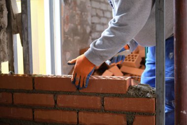 İnşaat işçisi duvar örüyor. Tuğla döşeme. Mason tuğla döşüyordu.