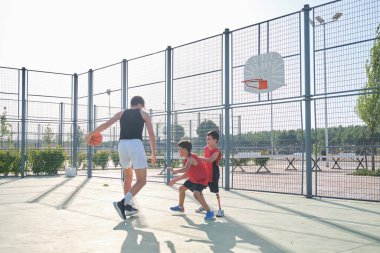 Basketbol oynayan üç kardeş, birinde bacak protezi var. Kardeşler basket oynuyor..