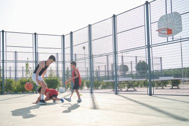 Basketbol oynayan üç kardeş, birinde bacak protezi var. Kardeşler basket oynuyor..