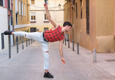 Sokakta dans eden uzun takma tırnaklı beyaz bir genç, çağdaş dans adımları..