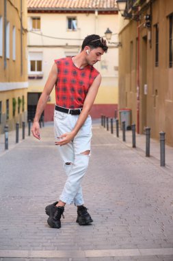 Sokakta dans eden uzun takma tırnaklı beyaz bir genç, çağdaş dans adımları..