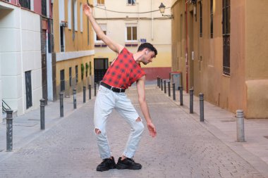 Sokakta dans eden uzun takma tırnaklı beyaz bir genç, çağdaş dans adımları..