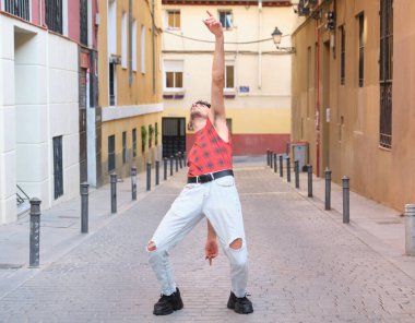 Sokakta dans eden uzun takma tırnaklı beyaz bir genç, çağdaş dans adımları..