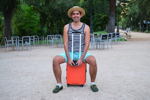 Туристичний Чоловік Сміється Дивлячись Сторону Сидячи Колісній Валізі Парку — стокове фото