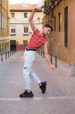 Sokakta dans eden uzun takma tırnaklı beyaz bir genç, çağdaş dans adımları..