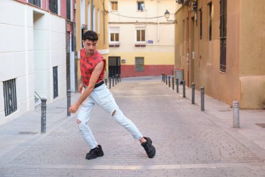 Sokakta dans eden uzun takma tırnaklı beyaz bir genç, çağdaş dans adımları..