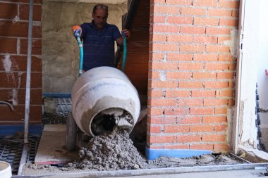 İnşaatçı beton karıştırıcıdan radyan zemine beton döküyor..