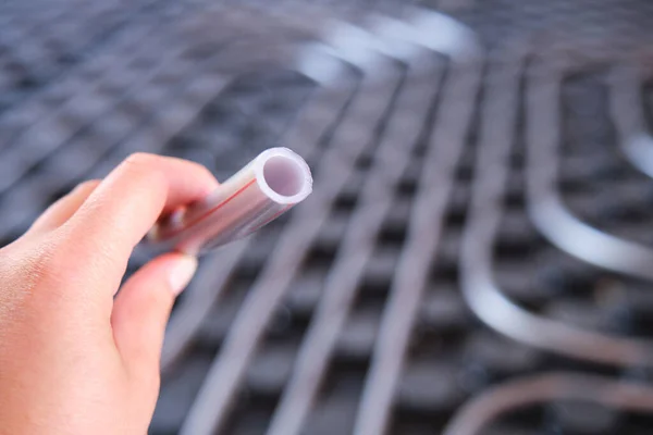 Tenuta a mano di un tubo di polietilene utilizzato per il sistema a pavimento radiante. — Foto Stock