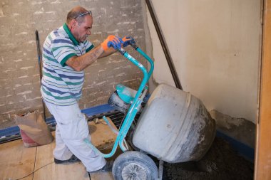 İnşaatçı beton karıştırıcıdan radyan zemine beton döküyor..