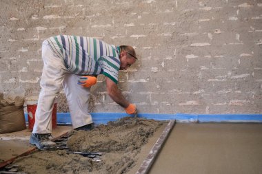 İnşaat işçisi ışıl ışıl zemine beton saçıyor..