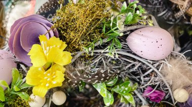 Beautiful Easter wreaths with spring flowers, speckled eggs and feathers, festive holiday decor.