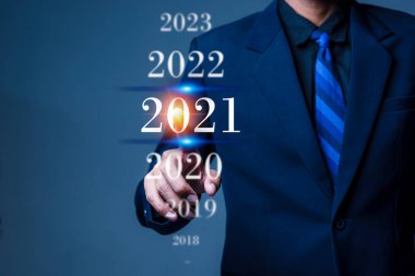 Digital infographic celebration 2021 year concept. Businessman pointing in the air with a virtual screen and popup 2021 text.