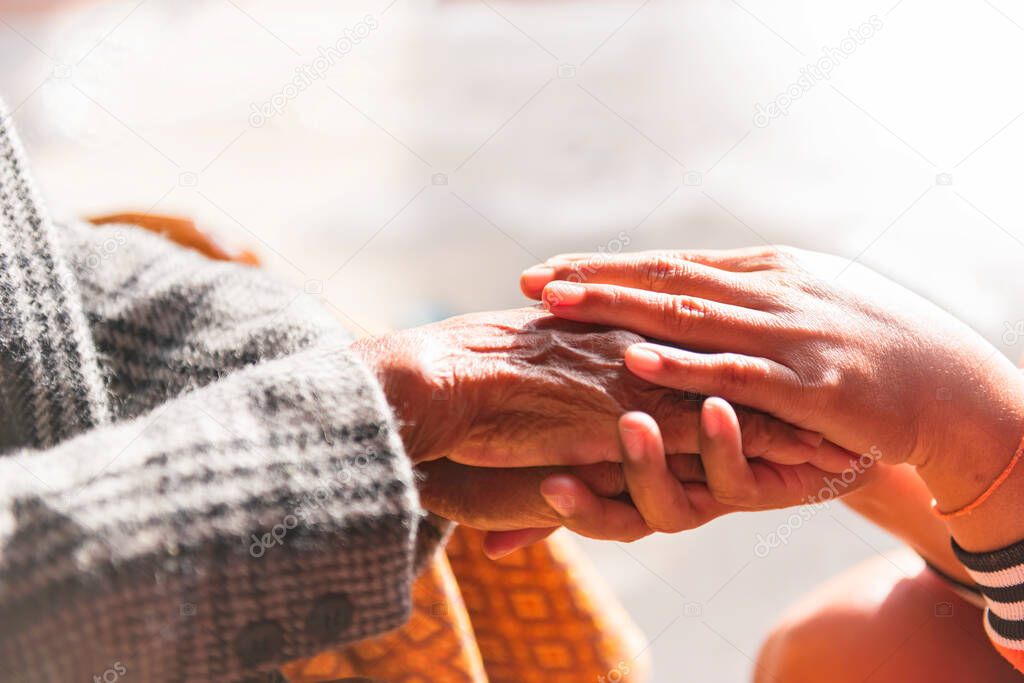 The daughter consoled the old mother and held her hand up close. Confidential conversations, strong connections, empathy and compassion, support during difficult life, near sharing ideas about heart pain.