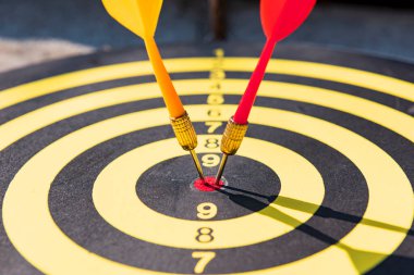 Dart tahtasında sarı ve kırmızı dart iğneleri var. İçlerinde parlayan ışık..