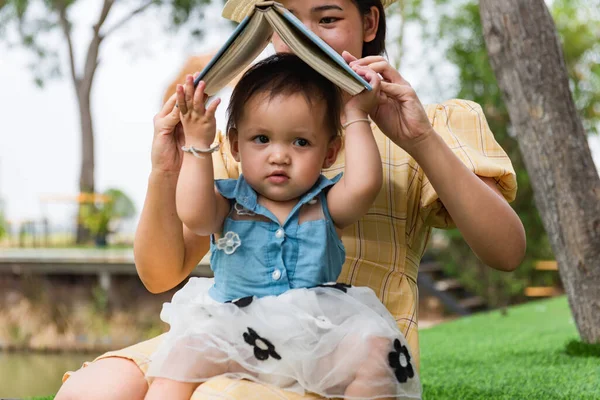 Linda Chica Leyendo Libro Con Madre Madre Asiática Hijo Concepto — Foto de Stock