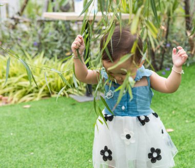 Young children walk in the park in autumn and spring costumes.