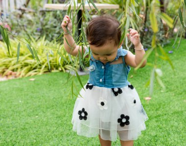 Young children walk in the park in autumn and spring costumes.