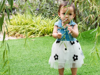 Young children walk in the park in autumn and spring costumes.