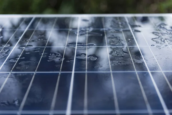 Nano kaplama üzerinde yağmur damlaları olan güneş paneli. Güneşin yenilenebilir enerjisi, yeşil enerji, kavram Yağmurdan Güç Yaratmak Güneş Panelleri Kullanmak.