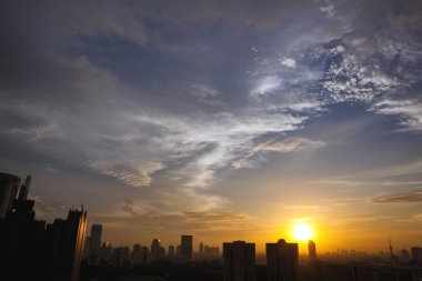 Dramatik gökyüzü günbatımı üzerinde bir şehir silüeti