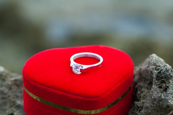 Ehering mit herzförmigem Symbol auf Strandfelsen — Stockfoto