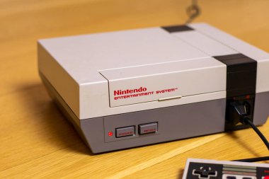 Bir Nintendo Eğlence Sistemi ve fişi takılı bir kontrol sistemi. NES popüler bir retro konsoldur.