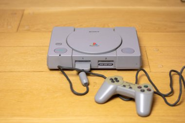 Orijinal bir Playstation 1, Sony tarafından, ahşap bir zeminde..