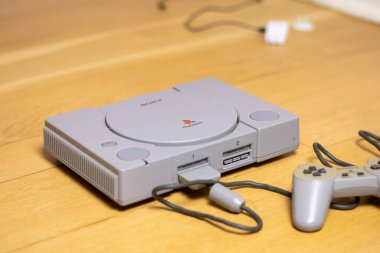 Orijinal bir Playstation 1, Sony tarafından, ahşap bir zeminde..