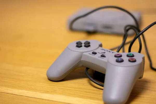 Playstation Classic 'in kumandası. Orijinal Playstation' ın ahşap bir zeminde yeniden canlandırma modeli..