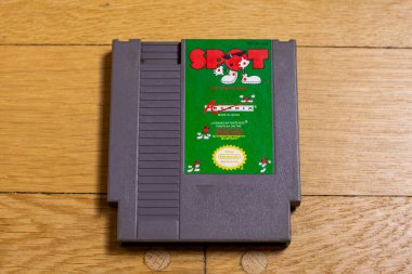 Ahşap zeminde Nintendo Eğlence Sistemi için bir Leke Kartuş.