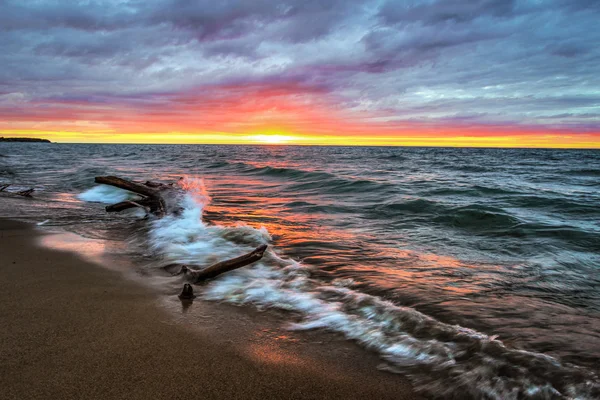 Sunset Beach Paradise üzerinde göl Huron dalgaların karaya attığı odun — Stok fotoğraf