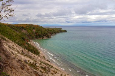 Steep Cliff On Coast. Massive sand dune forms a large cliff on the coast of Lake Superior at the popular Log Slide Overlook along the Pictured Rocks National Lakeshore in Michigan. clipart