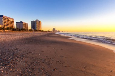 Myrtle Beach şehri şafak vakti Atlantik Okyanusu 'nun geniş kumlu sahilinde ufuk çizgisi..