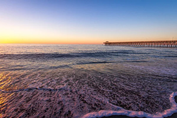 マートルビーチ日の出風景 米国サウスカロライナ州マートルビーチの大西洋の海岸に釣り桟橋と広い砂浜で日の出 — ストック写真