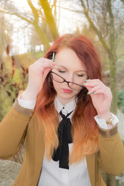 Woman puts glasses on — Stock Photo, Image