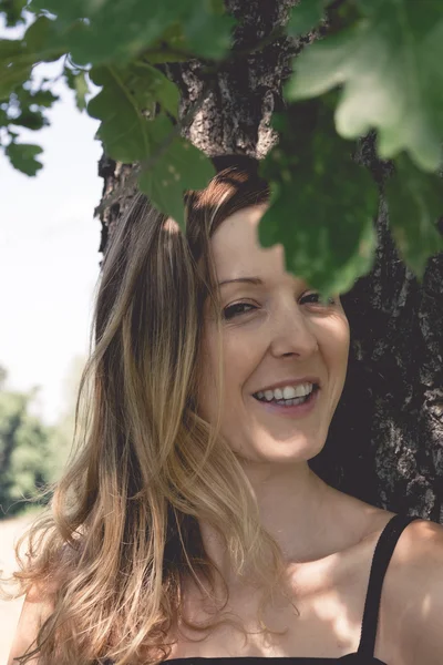 Χαμογελαστή γυναίκα σε ένα πάρκο — Φωτογραφία Αρχείου