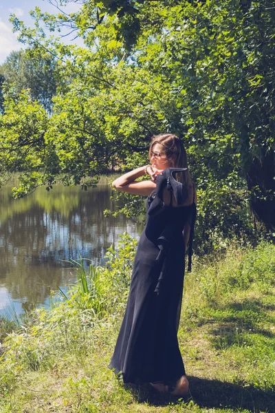 Mulher bonita com vestido de noite em um lago — Fotografia de Stock