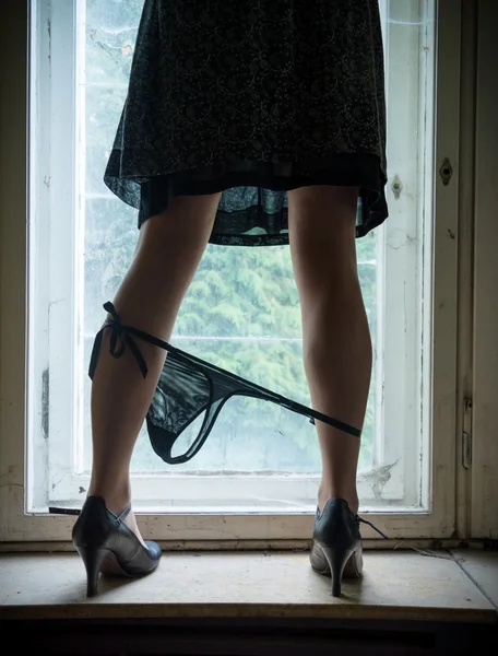 Kvinna ben på fönstret — Stockfoto