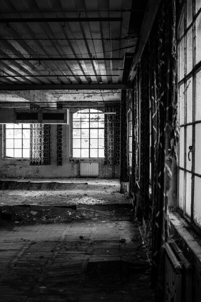 A dark scary abandoned factory floor in black and white