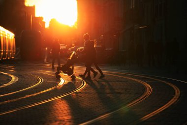 Bordeaux şehrinde gün batımında bebek arabasını iten bir kadının görüntüsü bulanık.