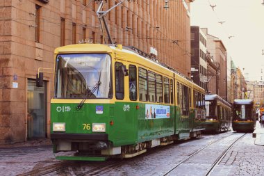 Helsinki, Finlandiya - 5 Ekim 2019: Helsinki şehrinin orta kesiminde insan taşıyan yeşil tramvay