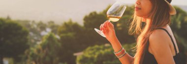 Terasta kırmızı şarap içen bir kadın, klasik tarzda.