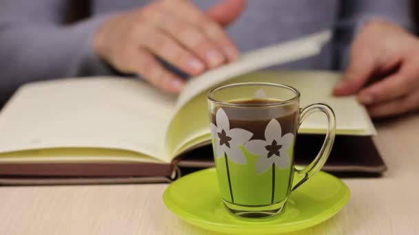 Una Taza Café Primer Plano Joven Hojeando Libro Cuaderno Fondo — Vídeo de stock