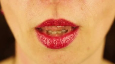 Genç bir bayanın dudaklarına yakın çekim. Kadın bir dilim mandalina yiyor. Yavaş çekim.